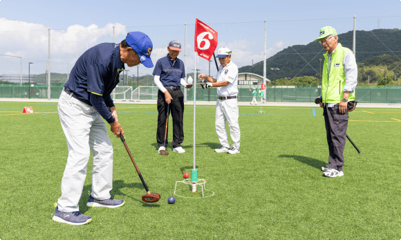 高齢男性がクラブでボールを打つ様子